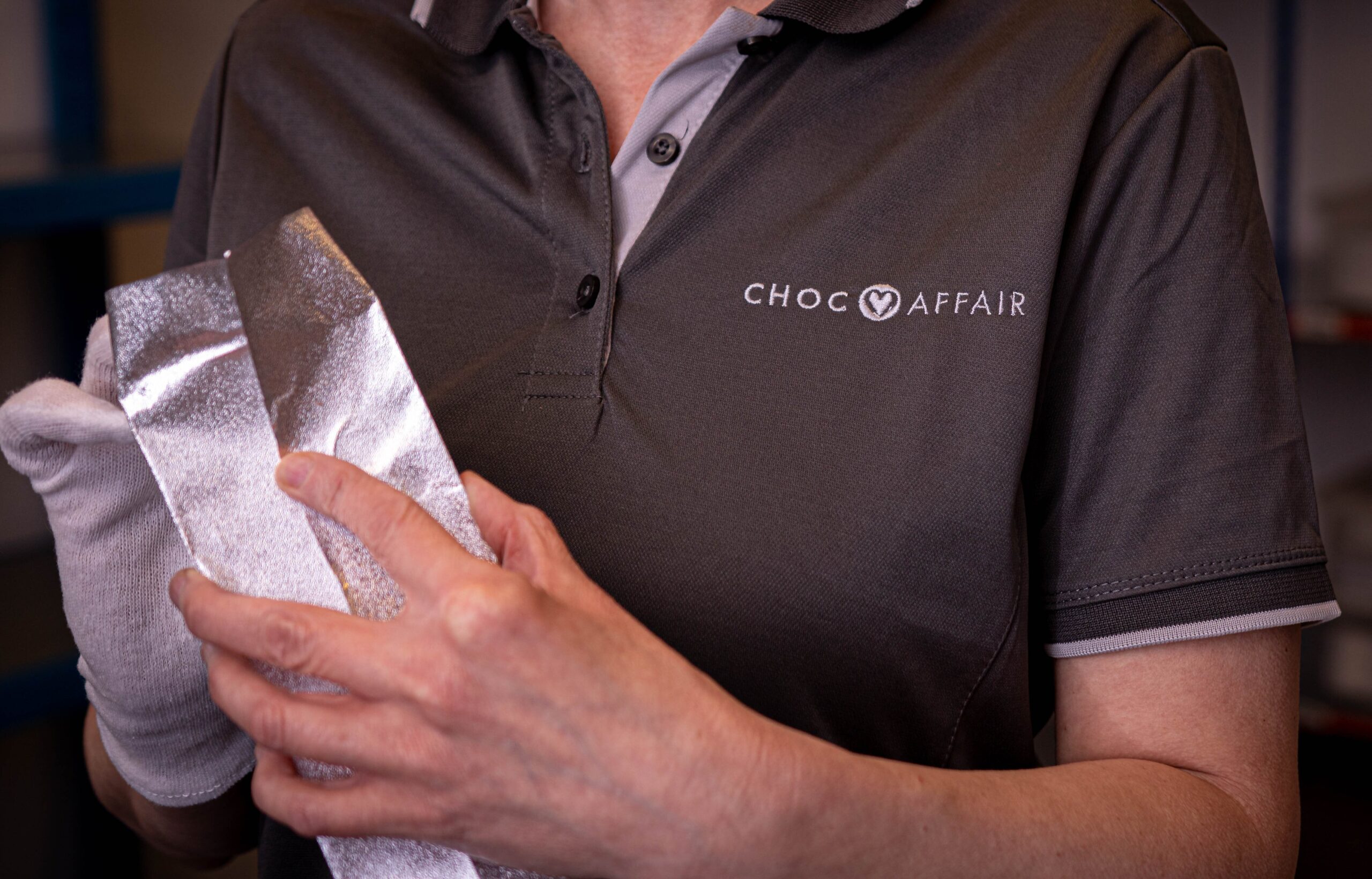 Person wearing Choc Affair t-shirt wrapping chocolate