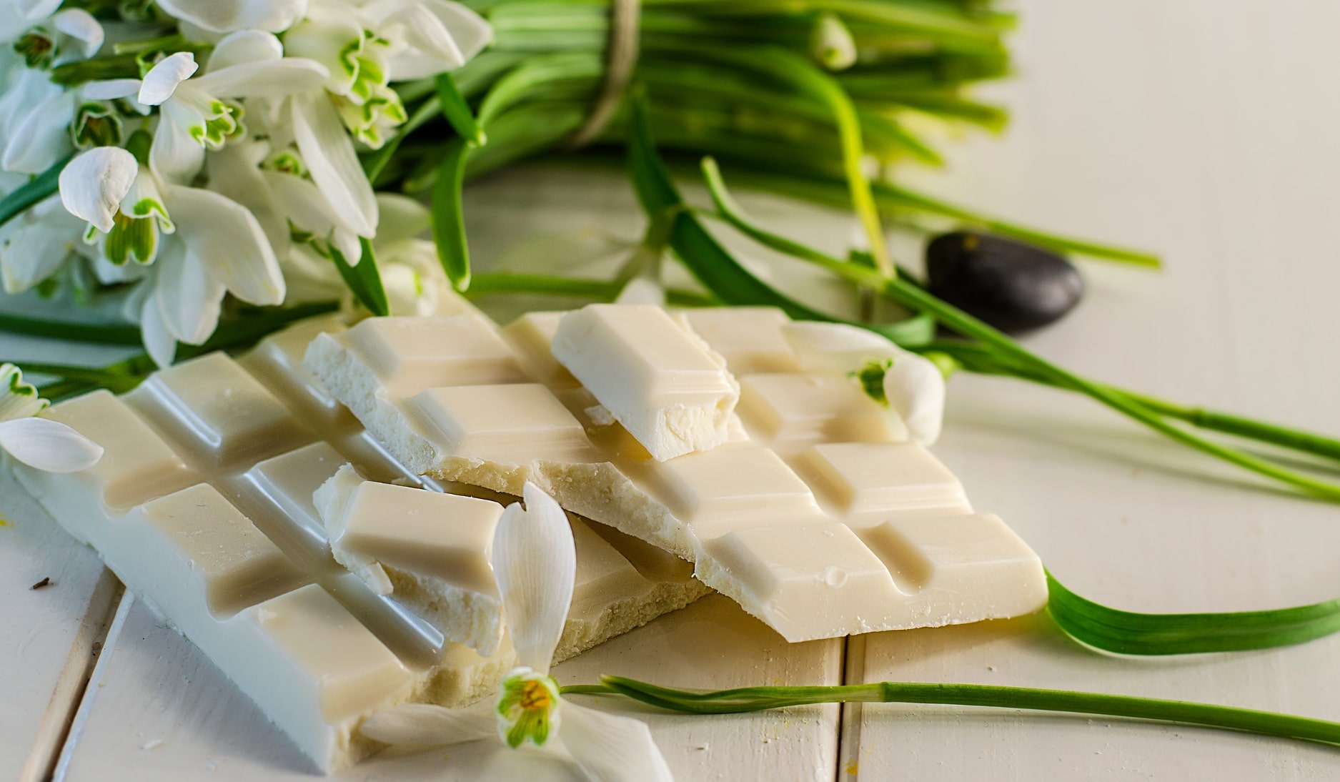 White chocolate laid next to white flowers