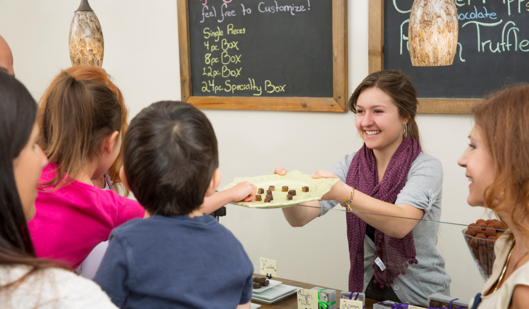 A women handing a crowd chocolates