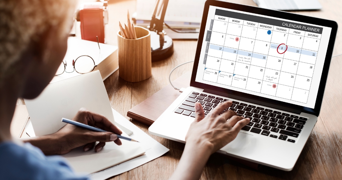 A women on a laptop looking at a calendar